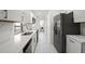 Modern kitchen featuring sleek white cabinets, stainless steel appliances, stylish tile backsplash and modern fixtures at 4107 Mulgrave Ave, North Port, FL 34287
