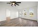 Bright living room with wood-look flooring, ceiling fan, and updated door and windows bringing in natural light at 4107 Mulgrave Ave, North Port, FL 34287