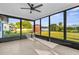 Screened patio featuring tile flooring and a ceiling fan, offering an open view of the spacious backyard at 4107 Mulgrave Ave, North Port, FL 34287