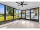 Enclosed patio with large windows offering scenic backyard views, a ceiling fan, and tile flooring at 4107 Mulgrave Ave, North Port, FL 34287