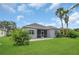 Backyard with tropical palms, lush grass, patio and screened-in porch at 11530 57Th Street E Cir, Parrish, FL 34219