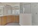 Bright bathroom featuring a glass shower, a wide mirror, and natural wood cabinetry at 11530 57Th Street E Cir, Parrish, FL 34219