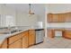 Kitchen showcasing granite countertops, stainless steel dishwasher, and wood cabinetry at 11530 57Th Street E Cir, Parrish, FL 34219