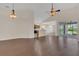 Open-concept living room with hardwood floors, kitchen view, and access to screened lanai at 11530 57Th Street E Cir, Parrish, FL 34219