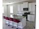 Modern kitchen features granite countertops, stainless steel appliances, and stylish red bar stools at 345 Mangrove Manor Dr, Apollo Beach, FL 33572