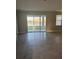 Open living room with tile floors and sliding glass doors leading to the patio at 345 Mangrove Manor Dr, Apollo Beach, FL 33572