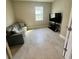 Cozy living room with tiled floor, features a comfortable couch and large television for relaxing at 345 Mangrove Manor Dr, Apollo Beach, FL 33572