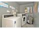Community laundry room featuring a commercial washer, dryer, and hot water heater at 6320 Newtown Cir # 20B1, Tampa, FL 33615
