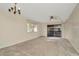 Inviting living room featuring neutral carpet, ceiling fan, and sliding glass doors to balcony at 6320 Newtown Cir # 20B1, Tampa, FL 33615