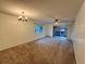 Spacious living room features soft carpet, neutral walls, natural light, and sliding glass doors to a balcony at 6320 Newtown Cir # 20B1, Tampa, FL 33615