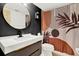 Modern bathroom with a sleek vanity, round mirror, and uniquely patterned shower curtain at 11419 Donneymoor Dr, Riverview, FL 33569
