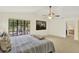 Airy main bedroom with window view, a ceiling fan and plush bedding at 11419 Donneymoor Dr, Riverview, FL 33569