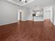 Open-concept living room with wood floors and seamless flow into kitchen and entry at 3328 Circleville St, North Port, FL 34286