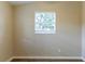 This bedroom features wood-look floors, neutral walls, and a window for natural light at 7216 E Emma St, Tampa, FL 33610