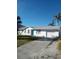 Charming single-story home featuring a two-car garage, well-maintained lawn, and a vibrant turquoise front door at 18686 Van Nuys Cir, Port Charlotte, FL 33948