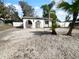 Charming white home with dark roof, decorative archways and abundant shell rock landscaping at 913 27Th E St, Bradenton, FL 34208
