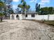 Charming white home with dark roof and arched entry, surrounded by well-kept landscaping at 913 27Th E St, Bradenton, FL 34208