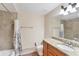A bathroom features a shower with tile surround, a granite countertop vanity and a mirrored wall cabinet at 606 Riviera Dunes Way # 604, Palmetto, FL 34221