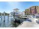 Dock featuring a boat lift and the building in the background, providing convenient and secure boat storage at 606 Riviera Dunes Way # 604, Palmetto, FL 34221