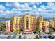 Stunning multi-story building with a lushly landscaped entrance and ample parking on a beautiful sunny day at 606 Riviera Dunes Way # 604, Palmetto, FL 34221