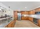 Spacious kitchen featuring granite countertops, wood cabinets, stainless steel appliances, and ample storage at 606 Riviera Dunes Way # 604, Palmetto, FL 34221