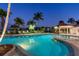 A resort-style pool features lounge chairs, lush landscaping, and a poolside gazebo at 606 Riviera Dunes Way # 604, Palmetto, FL 34221