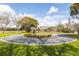 Circular driveway with a landscaped island featuring a horse statue and lush greenery at 3319 Powerline Rd, Lithia, FL 33547