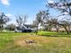 Wide view of home and expansive backyard with mature trees, fence line and covered porch at 6604 Stafford Terrace Ave, Plant City, FL 33565