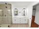 Elegant bathroom with double sinks, large mirrors, and a frameless glass shower at 6604 Stafford Terrace Ave, Plant City, FL 33565