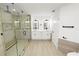 Modern bathroom featuring a glass shower, dual sink vanity, and wood-look tile at 6604 Stafford Terrace Ave, Plant City, FL 33565