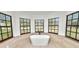 Bright bathroom featuring a modern soaking tub and large windows with a backyard view at 6604 Stafford Terrace Ave, Plant City, FL 33565