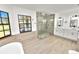 A luxurious bathroom showcases a glass enclosed shower, soaking tub, and double vanity with modern fixtures at 6604 Stafford Terrace Ave, Plant City, FL 33565