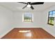 Bedroom featuring hardwood floors, a modern ceiling fan and multiple windows at 6604 Stafford Terrace Ave, Plant City, FL 33565