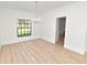 Bright dining room features wood floors, a window with backyard views and a chandelier at 6604 Stafford Terrace Ave, Plant City, FL 33565