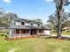 Inviting two-story home with brick accents, manicured landscaping, a covered porch, and an attached garage at 6604 Stafford Terrace Ave, Plant City, FL 33565