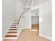 Staircase with wood treads and white risers in a bright, modern foyer with light wood flooring at 6604 Stafford Terrace Ave, Plant City, FL 33565