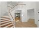 Bright and airy foyer featuring a staircase with wood and white railing and light wood floors at 6604 Stafford Terrace Ave, Plant City, FL 33565