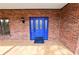 Close-up of the inviting blue front door with glass panels, set in a brick facade at 6604 Stafford Terrace Ave, Plant City, FL 33565