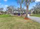 Charming front exterior of the house with a blue door and landscaped yard at 6604 Stafford Terrace Ave, Plant City, FL 33565