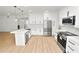 A bright, modern kitchen with white cabinets, stainless steel appliances, and a large center island at 6604 Stafford Terrace Ave, Plant City, FL 33565