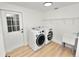 Well-lit laundry room with a modern washer and dryer, utility sink and exterior door at 6604 Stafford Terrace Ave, Plant City, FL 33565