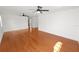A large, sunlit living room featuring hardwood floors and modern ceiling fans at 6604 Stafford Terrace Ave, Plant City, FL 33565