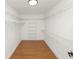Walk-in closet featuring custom shelving and hardwood floors at 6604 Stafford Terrace Ave, Plant City, FL 33565
