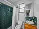 Cozy bathroom featuring a green tiled shower, a toilet, a wood vanity, and a mirror at 821 Greenview Dr, Apollo Beach, FL 33572