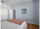 Bright bedroom featuring wood floors, a bed with light gray bedding, and artwork above the bed at 821 Greenview Dr, Apollo Beach, FL 33572