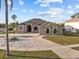 Stunning single-story home with manicured lawn, long driveway, mature palms and elegant architectural details at 821 Greenview Dr, Apollo Beach, FL 33572