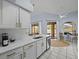 View of the kitchen, with counter seating, opening up to the living room and a view to the pool through the sliding glass door at 821 Greenview Dr, Apollo Beach, FL 33572