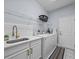 Bright laundry room boasting white cabinetry, subway tile backsplash, modern sink and newer washer/dryer units at 821 Greenview Dr, Apollo Beach, FL 33572