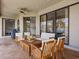 Covered patio with outdoor seating including wooden chairs, a fan, and sliding glass doors to the interior at 821 Greenview Dr, Apollo Beach, FL 33572