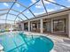 Beautiful screened-in pool with blue water, seating, a patio, and exterior views of the property at 821 Greenview Dr, Apollo Beach, FL 33572